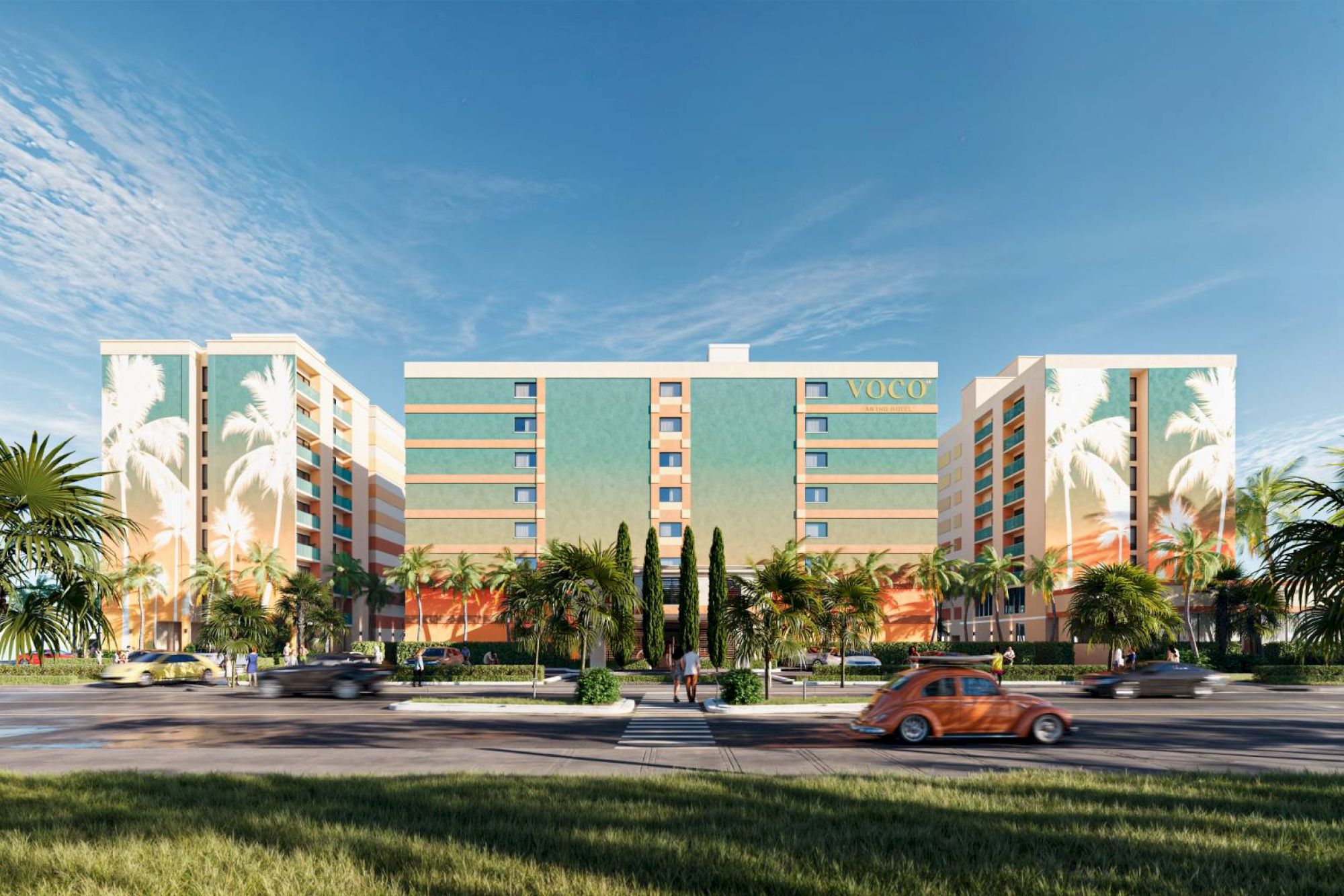 The image shows a modern apartment complex with palm trees and a grassy foreground; cars are driving along the street in front.