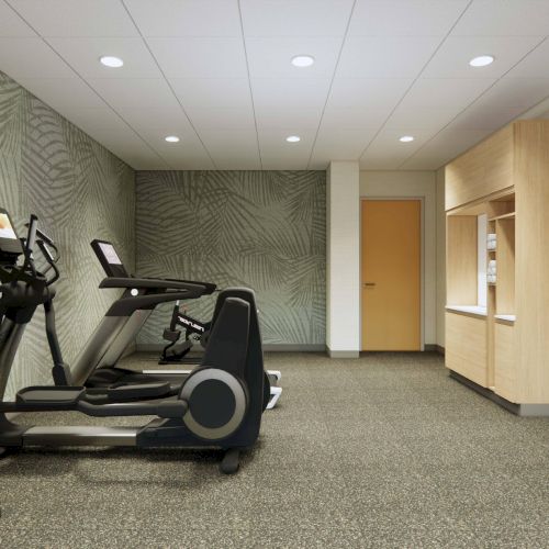 A small gym with treadmills, dumbbells, and wall-mounted exercise mats on a stand. The decor is modern with a patterned wall.