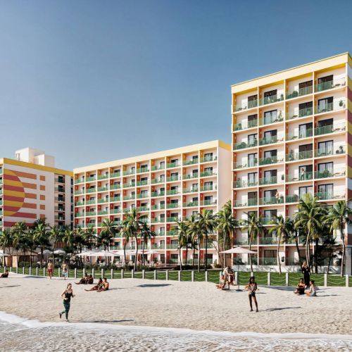 A beachfront hotel with colorful balconies, surrounded by palm trees and people enjoying the sandy beach and ocean waves.