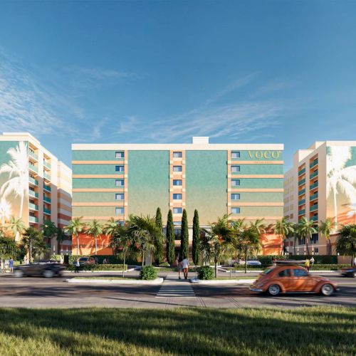 The image shows a mid-century modern building with palm trees and cars in the foreground, under a clear blue sky.