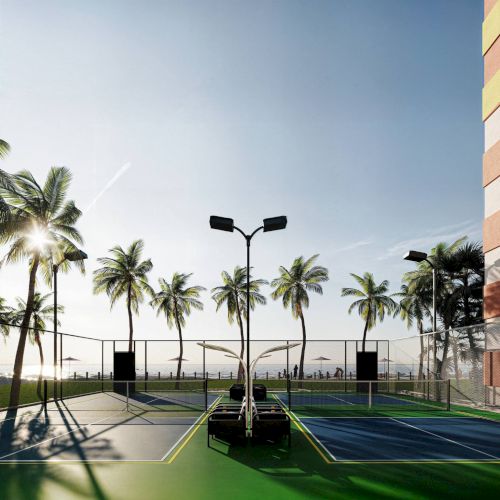 A sunny outdoor basketball court is surrounded by palm trees, with a colorful building nearby and a clear sky above.