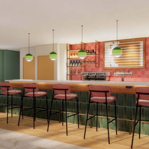 The image shows a modern bar with high stools, hanging lights, and an array of bottles on shelves, creating a stylish and inviting atmosphere.