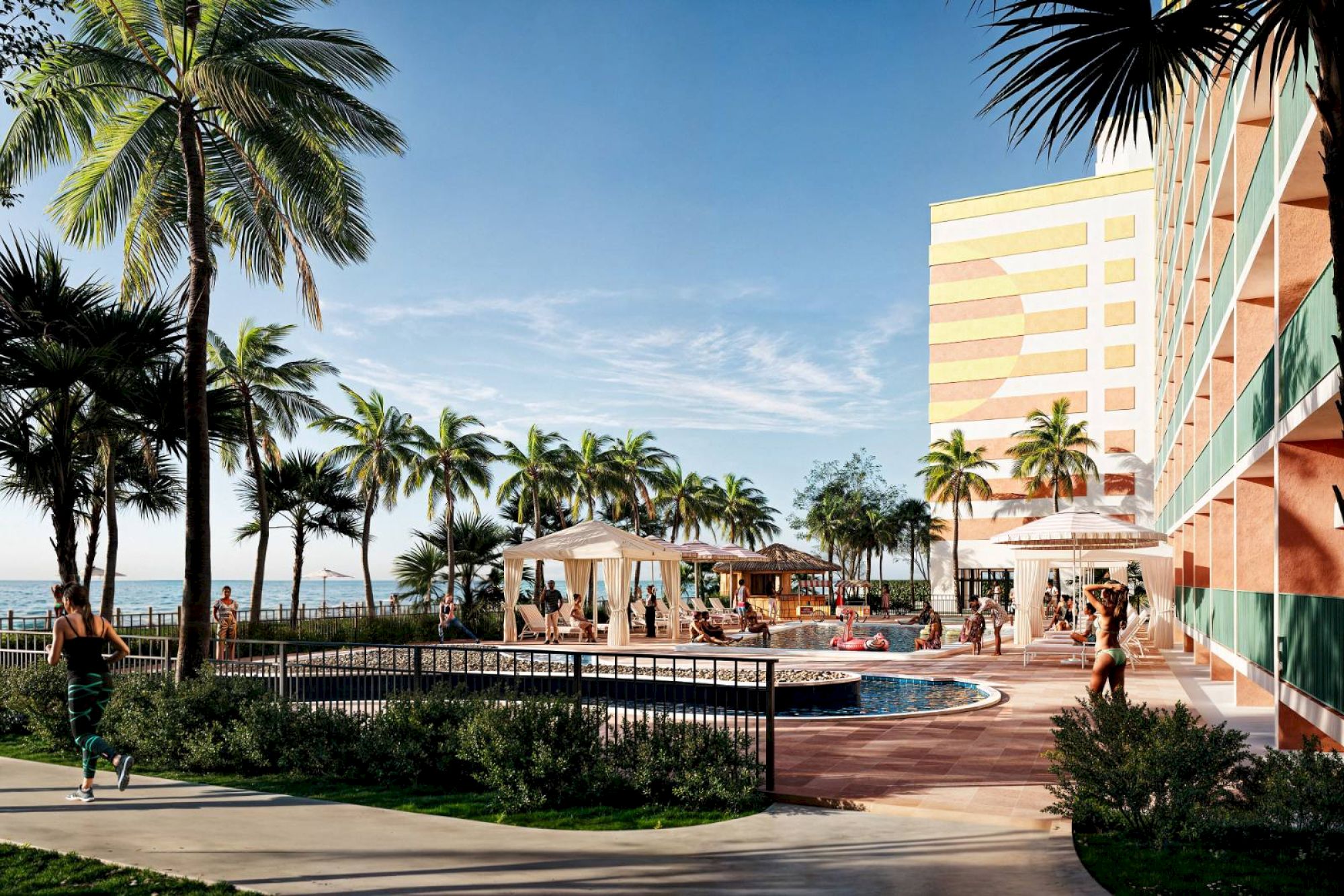 An outdoor pool area with people relaxing, surrounded by palm trees and a colorful building, under a clear blue sky.